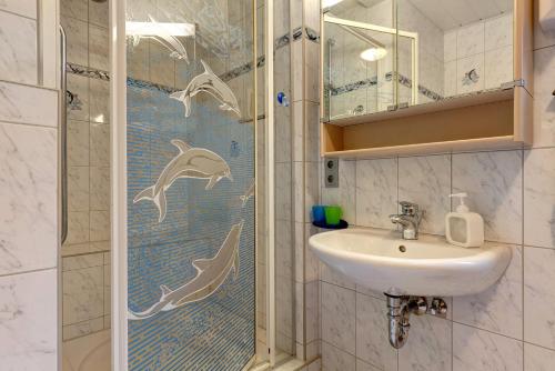 a bathroom with a shower with dolphins on the shower curtain at Im Grünen in Weil der Stadt