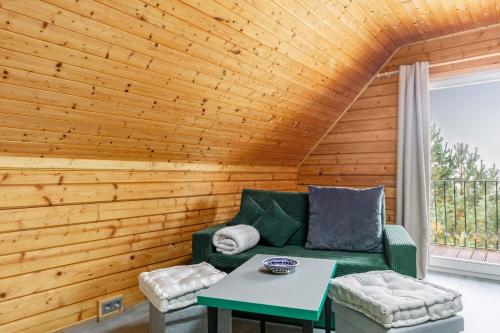 a living room with a green couch and a table at Holzhaus am Waldrand in Niederfinow