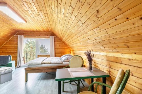 a room with a bed and a table at Holzhaus am Waldrand in Niederfinow