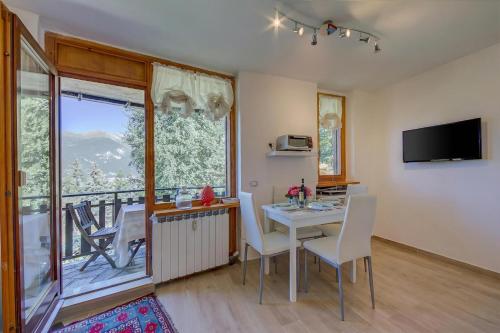 a dining room with a table and chairs and a balcony at Studio La Borracina Mountain View - Happy Rentals in Sauze dʼOulx