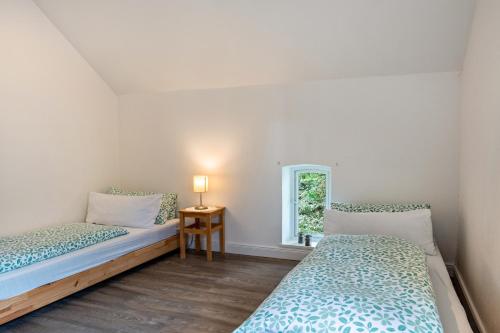 two beds in a room with a window at Ferienwohnung Flut am Weserstrand in Sandstedt