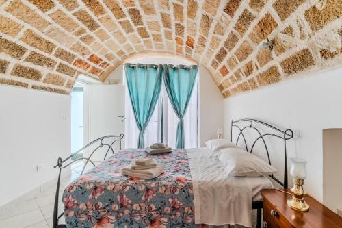 a bedroom with a bed and a window with blue curtains at Civico4 luxuryholidays in Casarano