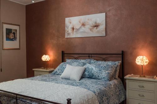 a bedroom with a bed with two night stands and two lamps at Villa Simona con giardino in Favara