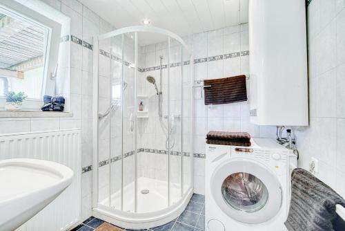 a bathroom with a washing machine and a shower at Ferienwohnung Seenähe in Mattsee