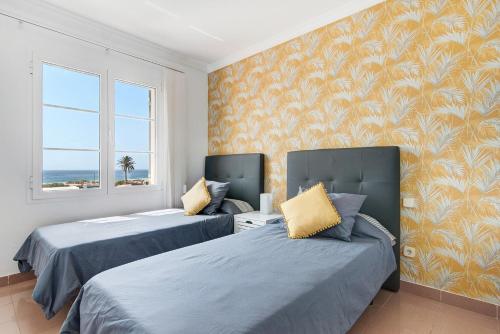 a bedroom with two beds and a window with the ocean at Santa Ana 23 in Playa del Ingles