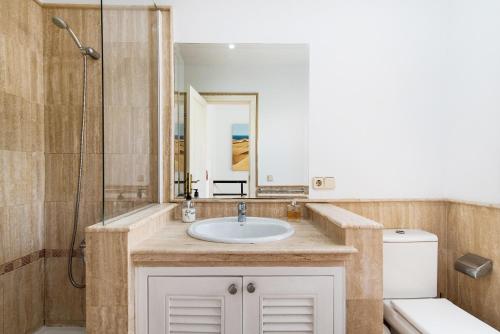 a bathroom with a sink and a toilet and a mirror at Santa Ana 23 in Playa del Ingles
