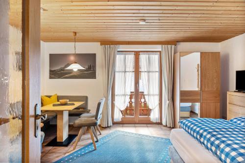 a bedroom with a bed and a desk and a table at Haus Verena Mittenwald in Mittenwald