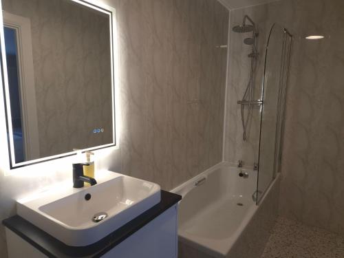 a bathroom with a sink and a shower and a mirror at The Bank House in Bundoran