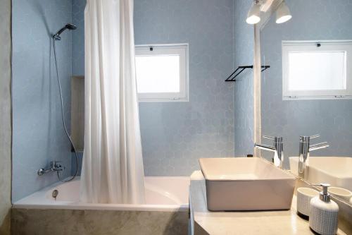 a bathroom with a tub and a sink and a shower at Balaia 9 in Olhos de Água