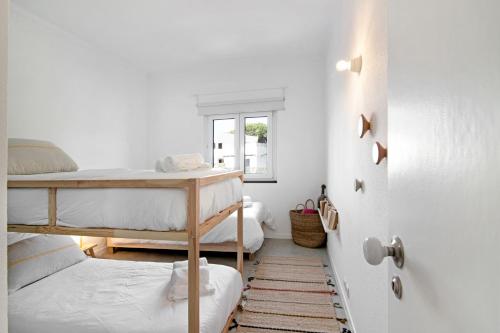 a bedroom with two bunk beds and a door at Balaia 9 in Olhos de Água