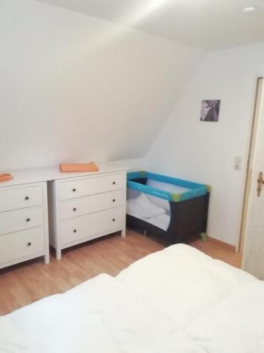 a bedroom with a bed and a dresser and a desk at Ferienwohnung Loewe in Plau am See