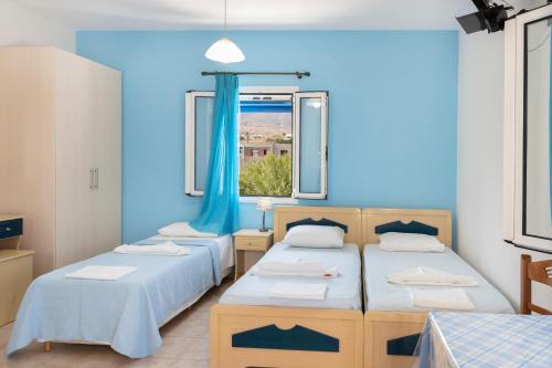 a bedroom with two beds and a window at Studios Ninemia Serifos 5 in Livadi