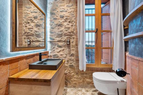 a stone bathroom with a sink and a toilet at Masia Can Divi in La Ametlla
