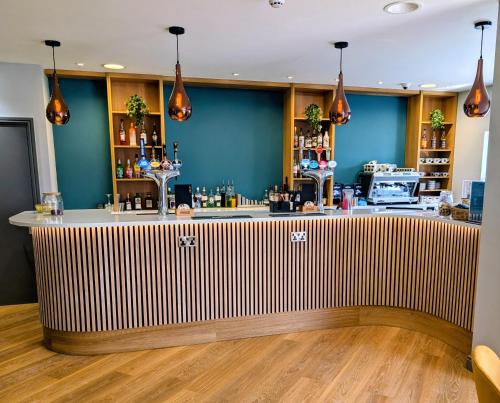 a bar with a wooden counter in a room at Passage House Hotel in Newton Abbot