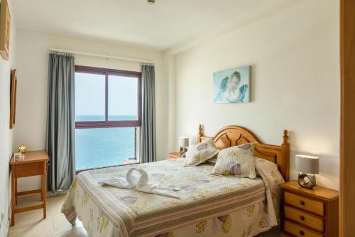 a bedroom with a bed with a view of the ocean at Su Eminencia in Mogán