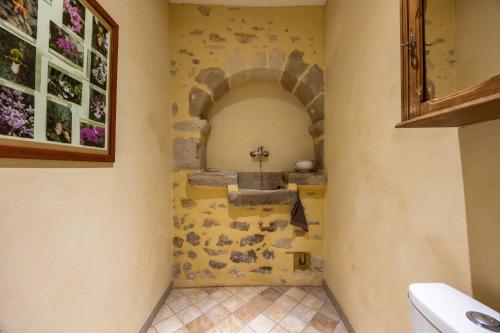 a bathroom with a sink and a stone wall at Appartement Andraut - Bazas in Bazas