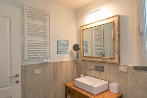 a bathroom with a sink and a mirror at Casetta Maya in Riparbella