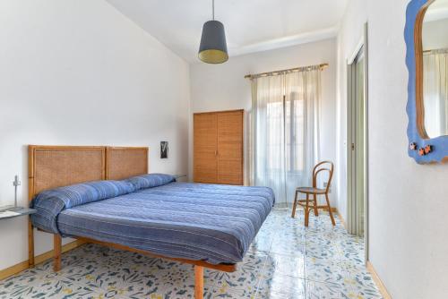 a bedroom with a bed with a blue blanket at Casa La Torre in Capoliveri