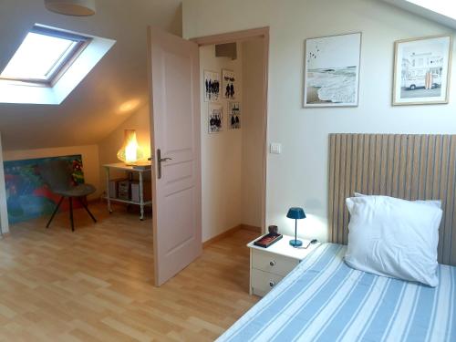 a bedroom with a bed and a skylight at Le Refuge Salin in Batz-sur-Mer