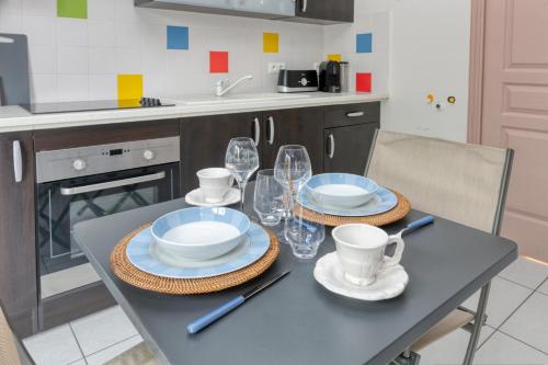 a kitchen with a table with plates and glasses on it at Le Refuge Salin in Batz-sur-Mer