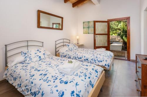 a bedroom with two beds and a mirror at Finca Es Carregador in Capdepera