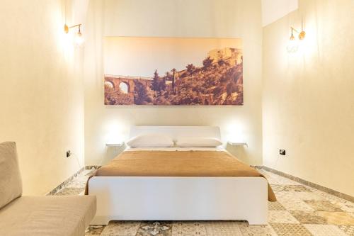 a bedroom with a bed with a painting on the wall at Sg Apartment Standard Plus in Massafra