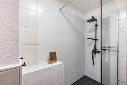 ein Badezimmer mit Dusche und einem Fernseher an der Wand in der Unterkunft Casa-Sarah Ferienwohnungen in Homberg