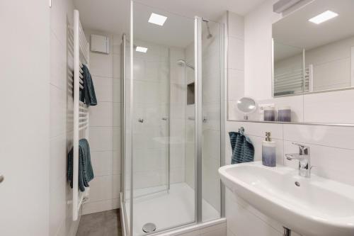 a white bathroom with a shower and a sink at Ferienwohnung Staffe in Bonndorf im Schwarzwald