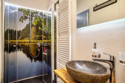a bathroom with a large stone sink and a shower at Butterei in Argenbühl