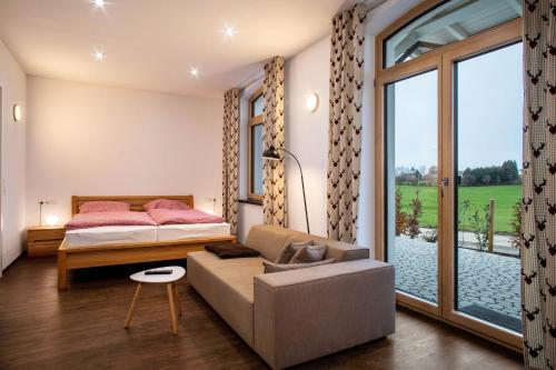 a bedroom with a bed and a couch and a window at Butterei in Argenbühl