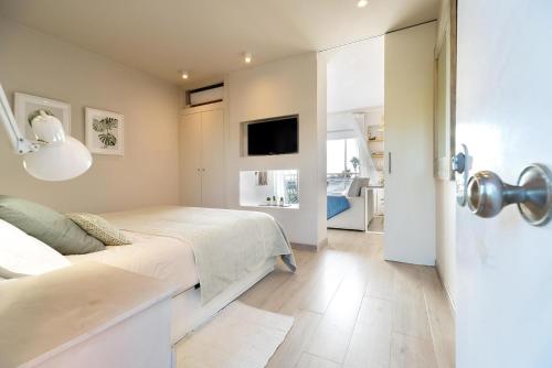 a bedroom with a bed and a flat screen tv at Ocean view apartment renovated in Gavà