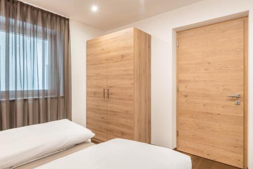 a bedroom with a wooden door and a closet at Aster Moments Apt Max in San Genesio Atesino