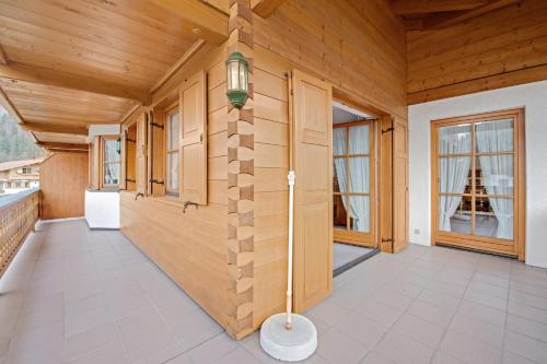 a large room with wooden walls and a porch with a lamp at Petrushof Ferienwohnung Taubensee in Oberwössen