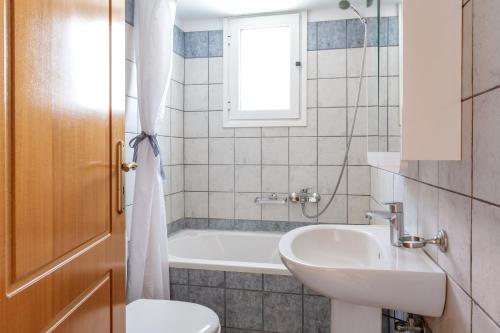 a bathroom with a sink and a tub and a toilet at Anemologio 304 Tinos in Agios Ioannis