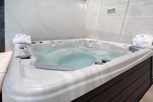 a jacuzzi tub with blue water in a bathroom at Villa Flor Rosa Piscina e Jacuzzi in Salir de Matos