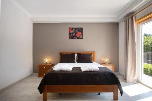 a bedroom with a bed with two white pillows at Villa Flor Rosa Piscina e Jacuzzi in Salir de Matos