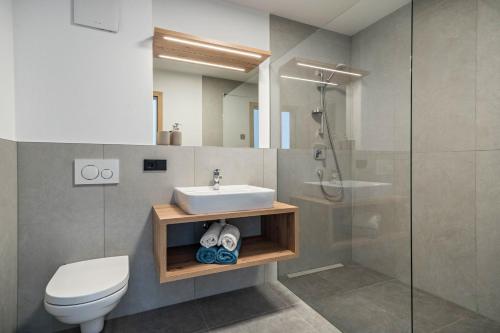 a bathroom with a sink and a toilet and a shower at sunnig Apartment Morgensonne in Vollan