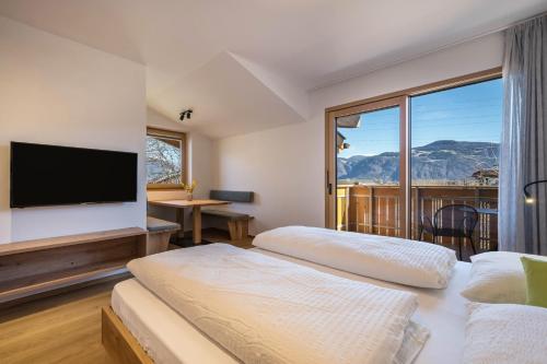 two beds in a hotel room with a large window at sunnig Apartment Morgensonne in Vollan