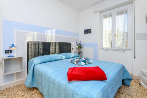 a white bedroom with a blue bed with a red pillow at Liver 201 in Tremosine Sul Garda