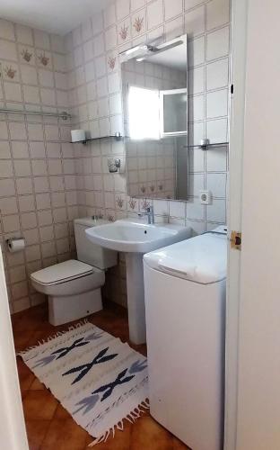 a bathroom with a sink and a toilet and a mirror at Apartament Bouganville in Alaior