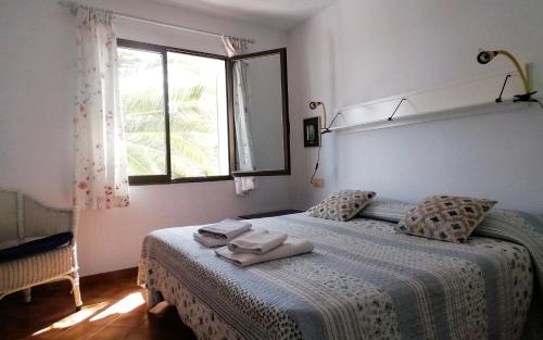 a bedroom with a bed with towels on it at Apartament Bouganville in Alaior