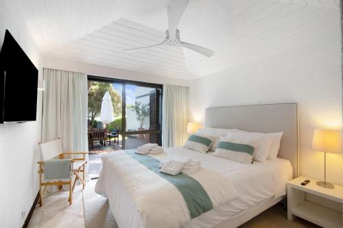 a white bedroom with a large bed with towels on it at Vilamoura com Piscina e Wifi in Vilamoura