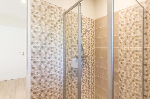 a shower with a glass door in a bathroom at Gîte les Monteils in Vesseaux