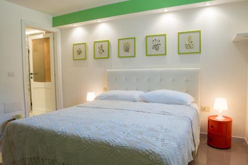 a bedroom with a bed with two pillows and two lamps at Villa Coral Bay in Alghero