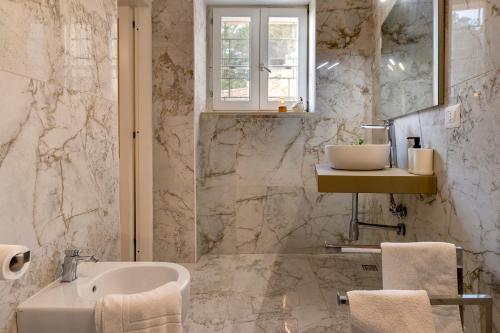 a bathroom with a sink and a mirror and a sink at Villa Coral Bay in Alghero