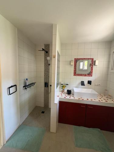 a bathroom with a tub and a sink and a mirror at Villa Maria in Cap Skirring