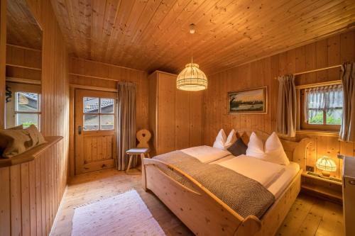 a bedroom with a large bed in a wooden room at Thaler-hof Ferienhaus Lärchnhittl in Lagundo