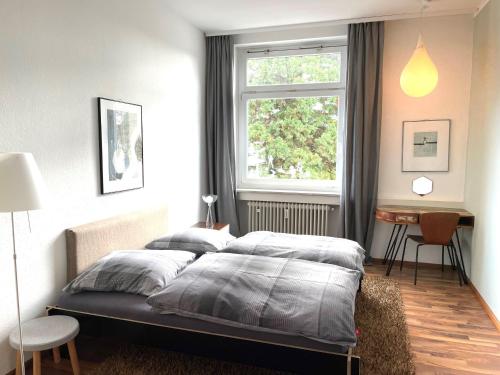 a bedroom with a large bed with a window at Bodenseeloft H E 66 in Kressbronn am Bodensee