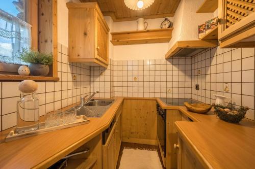 a kitchen with wooden cabinets and a sink at Thaler-hof Ferienhaus Lärchnhittl in Lagundo