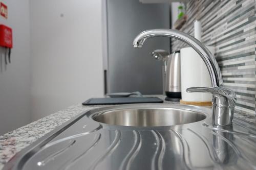 a kitchen sink with a faucet on a counter at Oásis Fonte Grande in Santo António